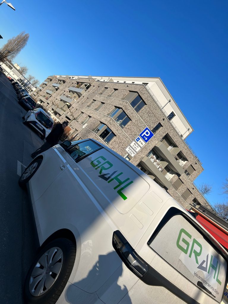 Firmenwagen in Düsseldorf mit grünem Hausmeisterservice Grahl Logo