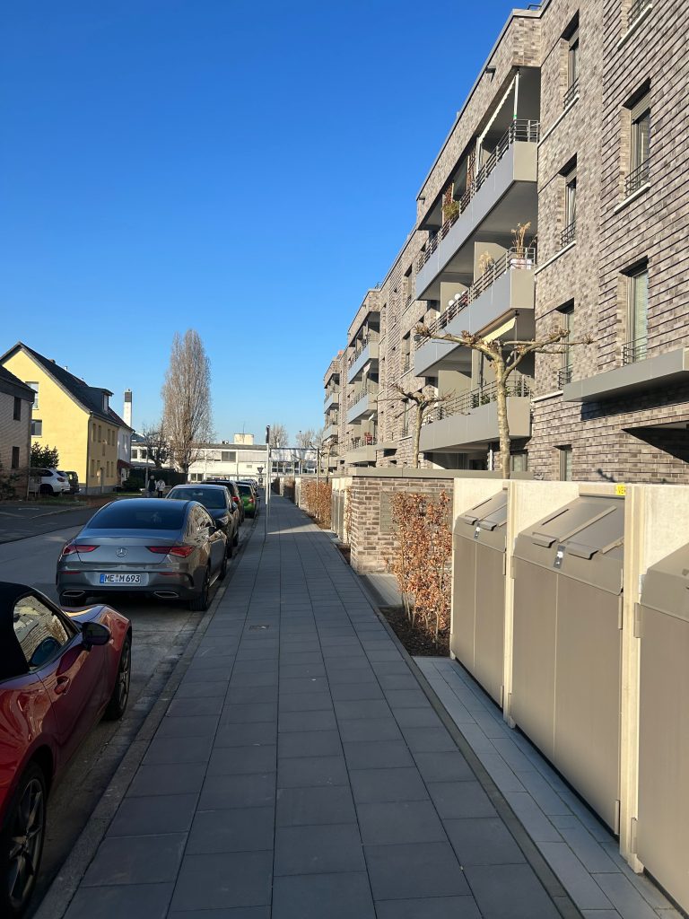 Fest installierte und verschlossene Abfallcontainer am Fußweg vor Mehrfamilienhaus in Düsseldorf